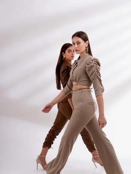 Two models walking in tandem, wearing complementary earth-toned outfits. This shot is great for showing how different pieces from a collection can be styled together.