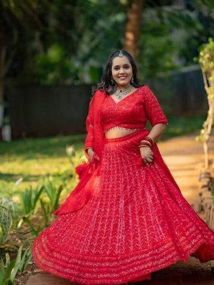 Our client is all smiles, twirling in her red rental lehenga. We love seeing our customers this happy.