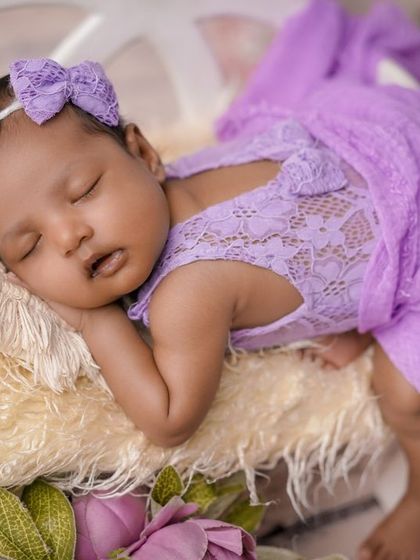 Dreaming in purple. This close-up shot of a sleeping baby in a lacy purple outfit is the picture of serenity.