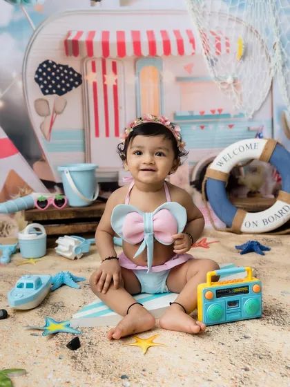A perfect, sweet portrait of a baby girl enjoying a day of sand and sun in the studio.
