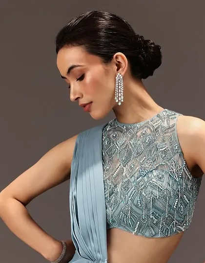 A profile view of a soft glam look for Kalki Fashion. This shot highlights the elegant, low bun hairstyle and the clean lines of the makeup, perfect for a sophisticated bridesmaid or cocktail party look.