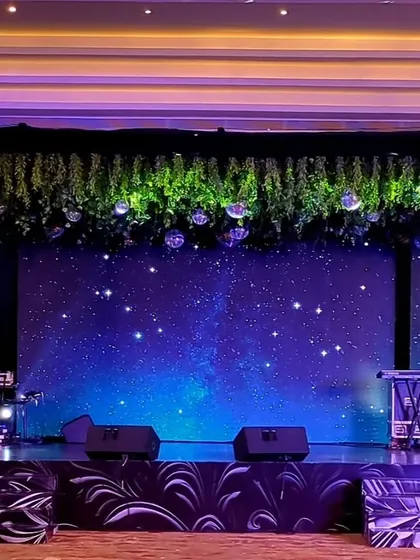 I transformed the Sangeet stage into a celestial dreamscape with a "starry night" LED backdrop, topped with hanging greenery and disco balls for a touch of magic.