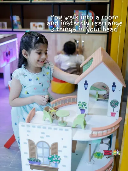 A young guest enjoying the dollhouse in our pretend-play area during a butterfly-themed party.