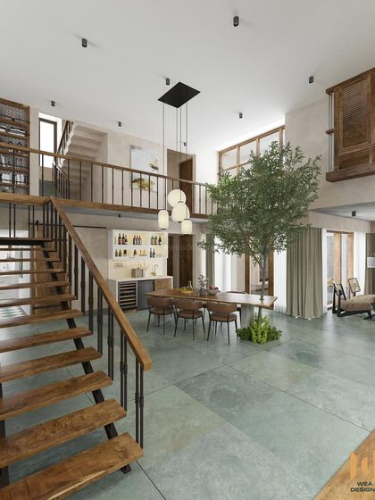 A view from the mezzanine level, showing the open-plan layout with the staircase, bar counter, and dining area.