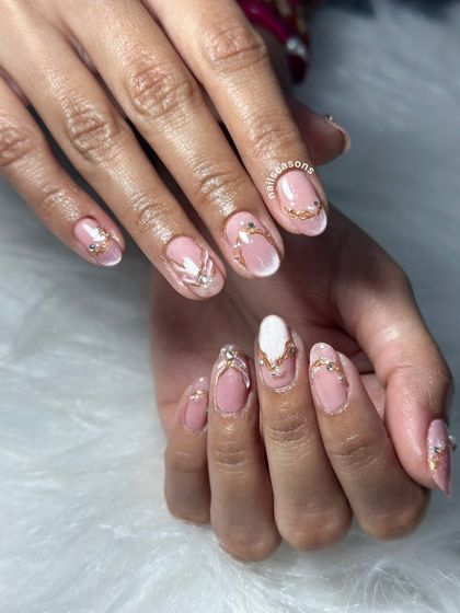 For this bridal set, we used a soft pink base with delicate gold wire work and strategically placed rhinestones. The white accent nail adds a touch of classic elegance.