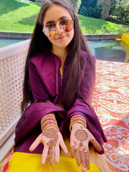 A young client with a simple and sweet design. One hand has a traditional mandala, while the other has a lighter pattern, perfect for kids or guests at a wedding.