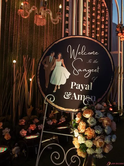 A personalized welcome sign for the sangeet, perfectly integrated into the entrance decor. The custom illustration and elegant script add a personal touch to the grand design.