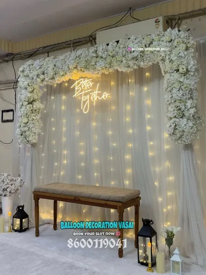 Another view of the elegant white floral arch setup. The design includes lanterns and vases with flowers at the base, creating a complete and polished look for your celebration.