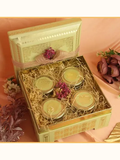 An elegant gift box containing four jars of premium dry fruits or sweets. The tin box itself is a beautiful keepsake, making this a simple yet sophisticated gift.