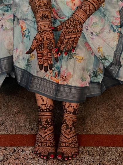 A beautiful shot showing the bride's hands and feet, with cohesive patterns that tie the whole look together.