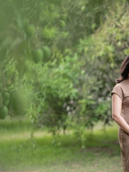 An outdoor maternity session surrounded by the calm of nature. The soft, natural light and green surroundings create a peaceful and organic feel.