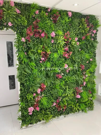 A beautiful green wall with pink and red flowers, designed to create an archway effect around a door.