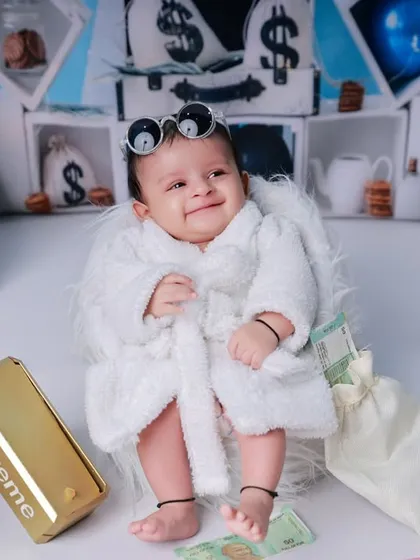 This little boss is making it rain. The playful money gun prop adds an extra layer of fun to our popular and humorous "Boss Baby" themed shoot.