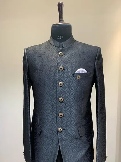 A classic black embossed Jodhpuri suit. The subtle texture of the fabric gives it a luxurious feel, making it perfect for a formal reception.