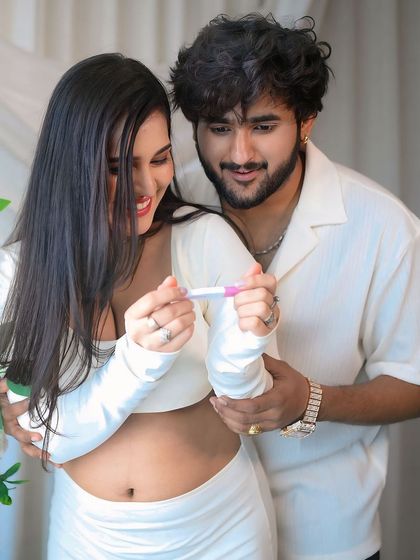 A joyful pregnancy announcement. The couple holds up a positive pregnancy test, their faces full of happiness and excitement, in a beautifully decorated studio setting.