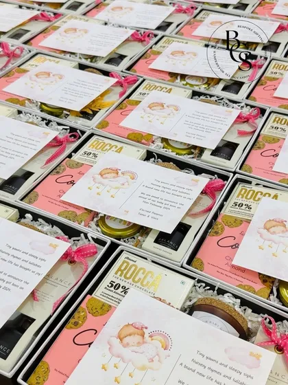 These sweet and simple baby announcement boxes are filled with cookies and other treats. The personalized card with a sleeping baby illustration adds a heartwarming touch to the happy news.