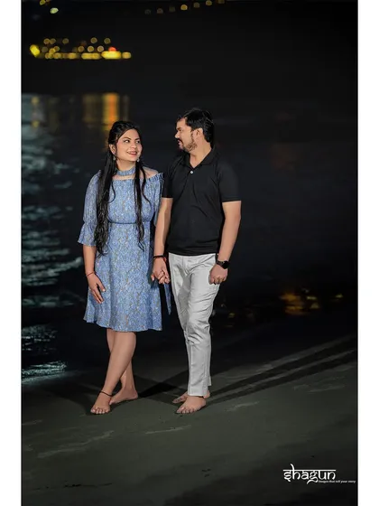 Holding hands and sharing a smile, with the dark water and distant lights creating a beautiful contrast. This is a simple yet powerful image of togetherness.