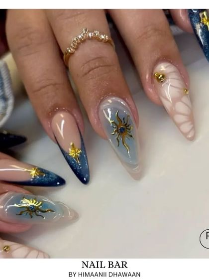Celestial-themed nail art featuring 3D sun and star charms on a dreamy blue and nude base. A truly unique and magical design.
