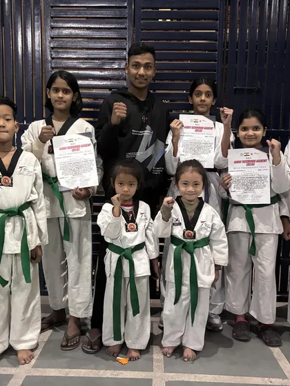 Our champions with their fists up, celebrating their new belts. This picture captures the excitement and sense of accomplishment after a successful belt test.