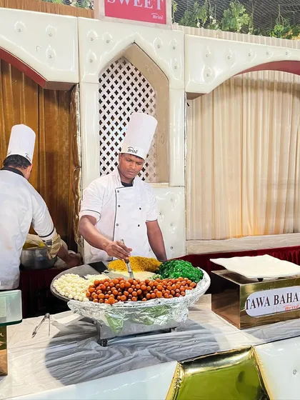 The Tawa Bahar station, a live dessert counter featuring an assortment of small Indian sweets like Gulab Jamun and Rasgulla, served warm.
