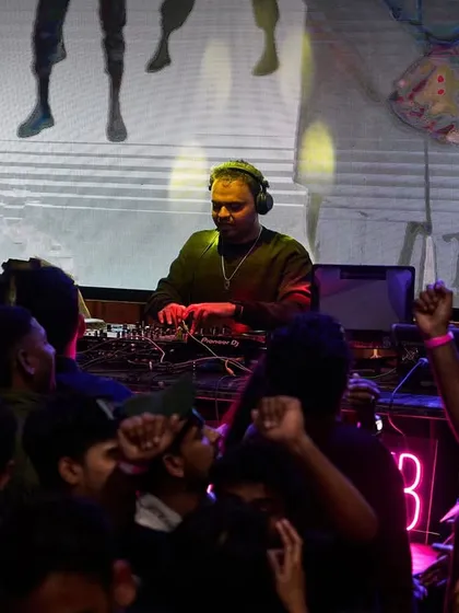Me at the decks with my VJ visuals playing on the screen behind.