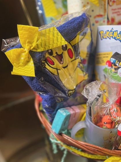 A close-up of the Pokémon-themed goodies, including a character towel and a themed mug.
