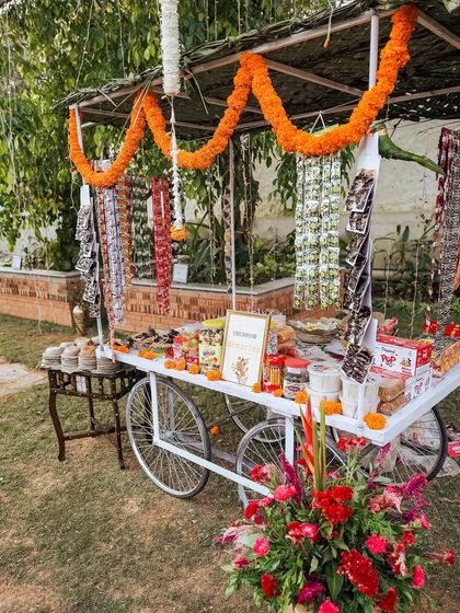 A full view of the charming 90s candy cart, decorated with marigold garlands.