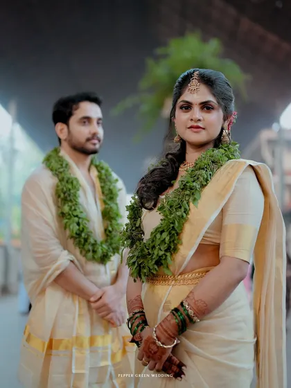 An elegant portrait of the couple at Guruvayur temple, the bride looking confidently at the camera.