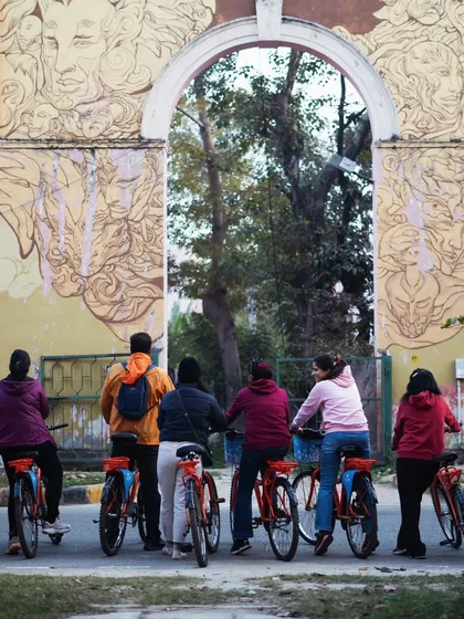 Our riders pause at one of the green gates leading into the residential blocks of Lodhi Colony, framed by beautiful artwork.