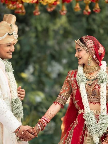 A tender moment of holding hands during the wedding ceremony, symbolizing their lifelong promise to each other.