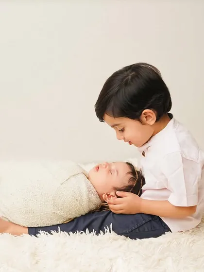 A tender moment as a big brother watches over his sleeping sibling, who is resting on his lap. This setup is all about trust and connection.