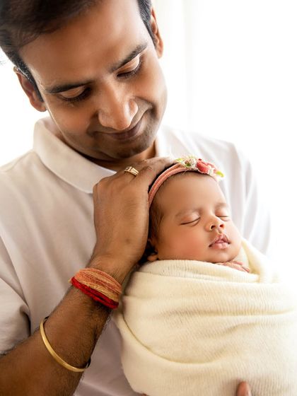 A father's gentle touch, soothing his sleeping baby girl. These quiet, unposed moments are often the most powerful.