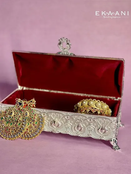 Store your precious keepsakes in this stunning silver-plated box, adorned with intricate engraved details and a rich red velvet interior. It is perfect as a jewelry holder or a statement piece for your space.