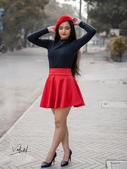 A classic pose from our Parisian-inspired photoshoot. The vibrant red of the beret and skirt pops against the black top, creating a timeless and chic look reminiscent of street style in Paris.