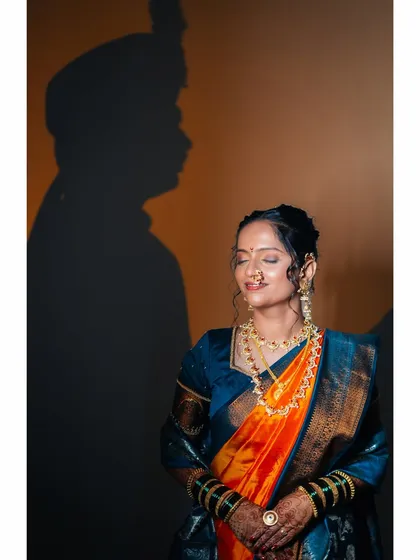 A creative and symbolic portrait. The bride stands in the light with her eyes closed in blissful thought, while the shadow of her groom is cast on the wall beside her, signifying their union.