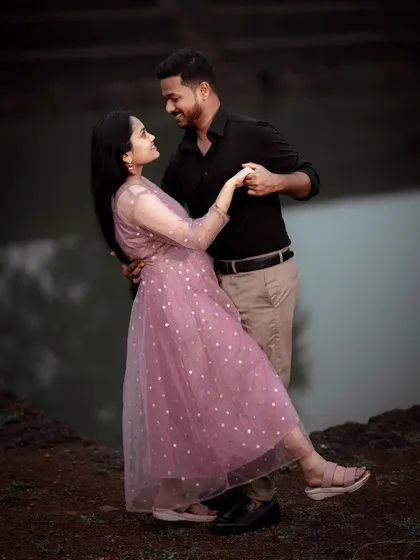 A couple shares a romantic dance by the water's edge, their pose elegant and full of love, perfect for a pre-wedding album.