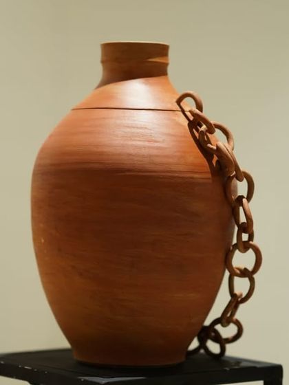 This terracotta piece is an exploration of form, featuring a smooth, wheel-thrown body with a hand-built chain attached. It plays with the ideas of connection and containment.