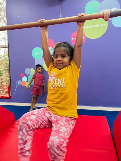 This 'mini queen' shows her strength as she hangs from the bar. Every child is encouraged to push their limits in a supportive way, celebrating their effort and growing confidence.
