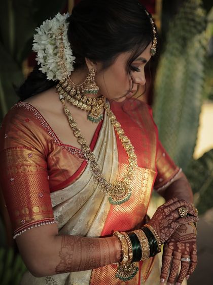 A close-up on the details of this serene South Indian look. The makeup is soft and elegant, perfectly complementing the heavy temple jewelry and the rich silk saree.