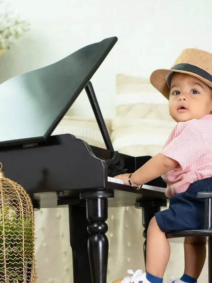 A little musician looking sharp in his hat. The piano theme is a classic and sophisticated choice for a toddler's portrait session.