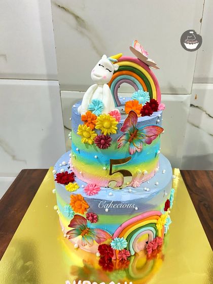 A different angle of the beautiful 4kg unicorn cake. The combination of rainbow stripes, flowers, and the unicorn topper makes it a truly magical centerpiece.
