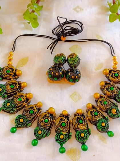 A green and gold version of the temple necklace. The pop of color adds a fresh touch to the traditional design.