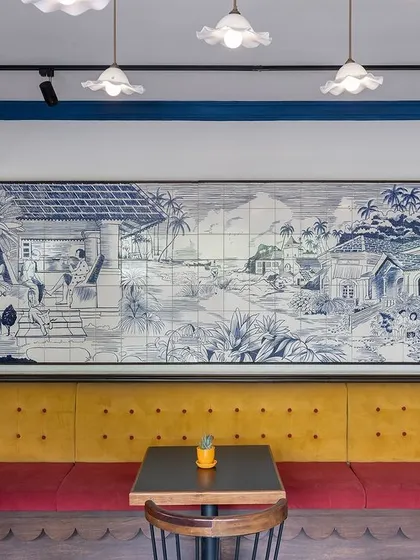 To bring a piece of Goa to Bangalore for Klaa Kitchen, we commissioned a custom, hand-painted tile mural depicting a classic Goan village scene. Paired with a vibrant yellow upholstered bench and warm lighting, this feature wall serves as the heart of the restaurant, creating an atmosphere of warmth and nostalgia.