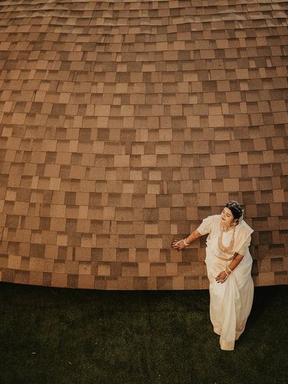 A minimalist and artistic bridal portrait. The high-angle shot and the textured background create a modern and unique composition that highlights the bride's form and grace.