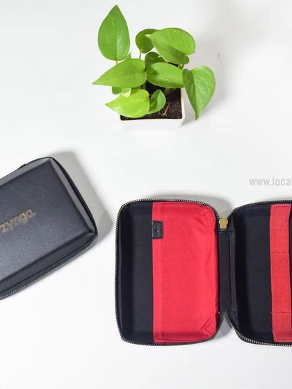 A closer look at the custom tech pouch for Zynga, showing the black exterior with gold branding and the organized red interior.