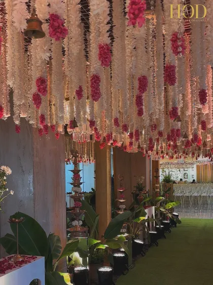 A side view of the floral walkway, showing the traditional brass lamps lining the path and adding a warm, traditional glow.