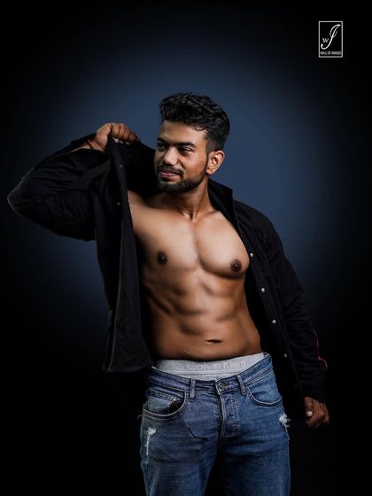 Capturing a moment of movement, as if the subject is putting on or taking off his shirt. This adds a candid, lifestyle feel to the fitness shoot while still highlighting the core and chest.