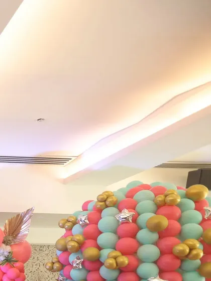 A vibrant balloon wall in shades of pink, teal, and gold, creating a cheerful and festive backdrop for the baby shower celebration.