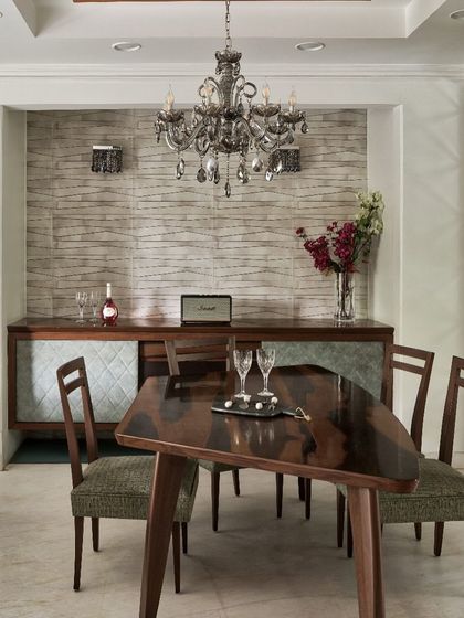 At The Classic Modern Storey, this dining area reclaims the joy of gathering. The boomerang-inspired table is crafted to encourage shared meals, while the classical chandelier adds a touch of elegance, balancing contemporary and timeless design.