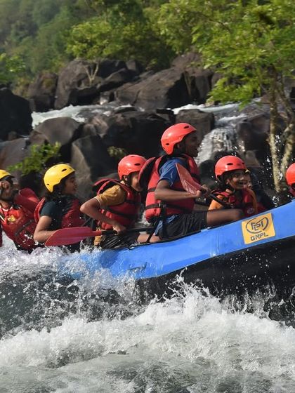 A close-up of participants' focused and excited faces as they brace for a rapid on the Kali river.